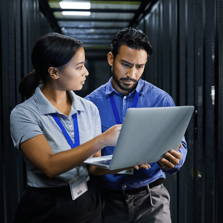 Woman and man looking at a laptop in server room